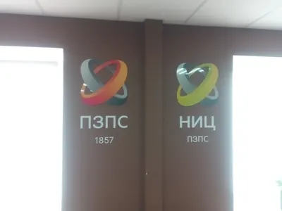 Интерьерные логотипы из объёмных элементов на коричневой стене офиса