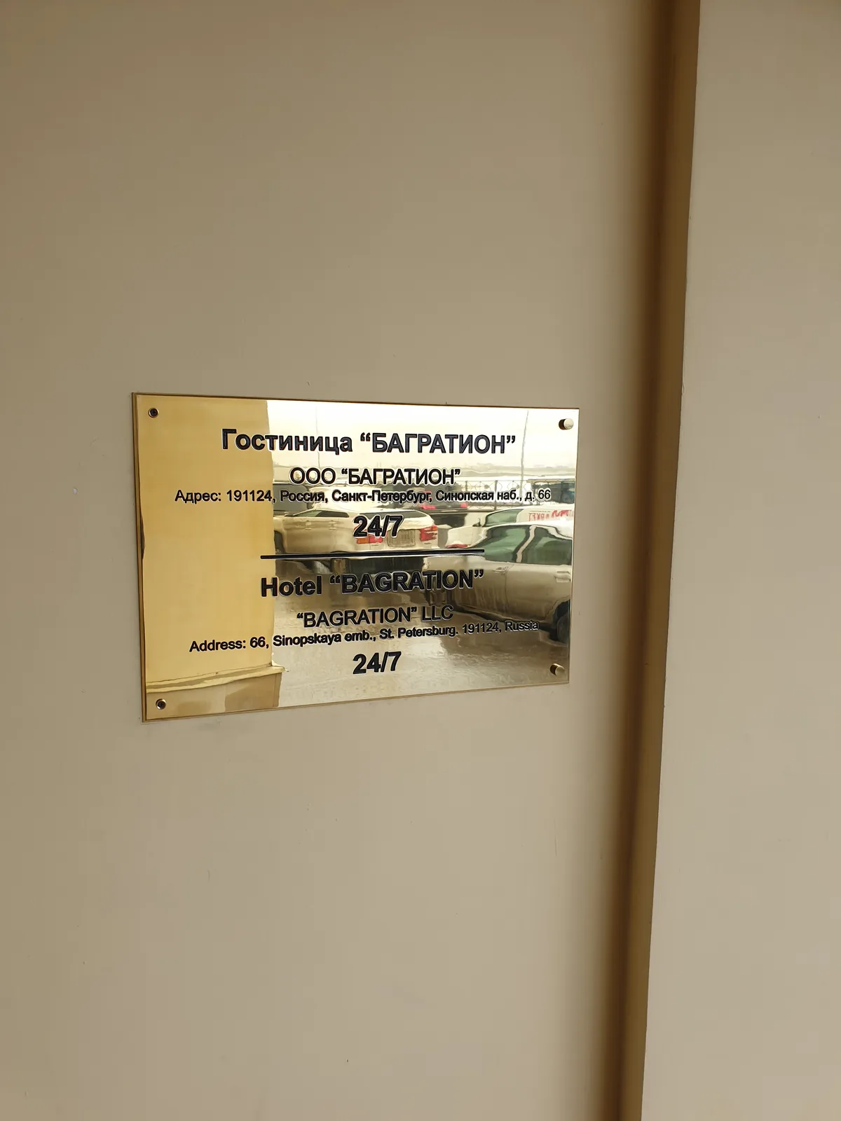 Латунная фасадная табличка гостиницы на стене у входа