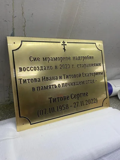 Латунная табличка с гравировкой на столе в мастерской