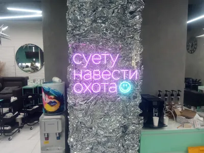 Неоновая надпись со смайлом на колонне в салоне красоты