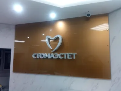 Интерьерная вывеска стоматологии: объёмный логотип на коричневой панели