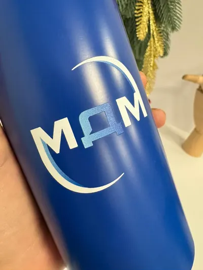 Белый логотип на синей матовой бутылке, крупный план